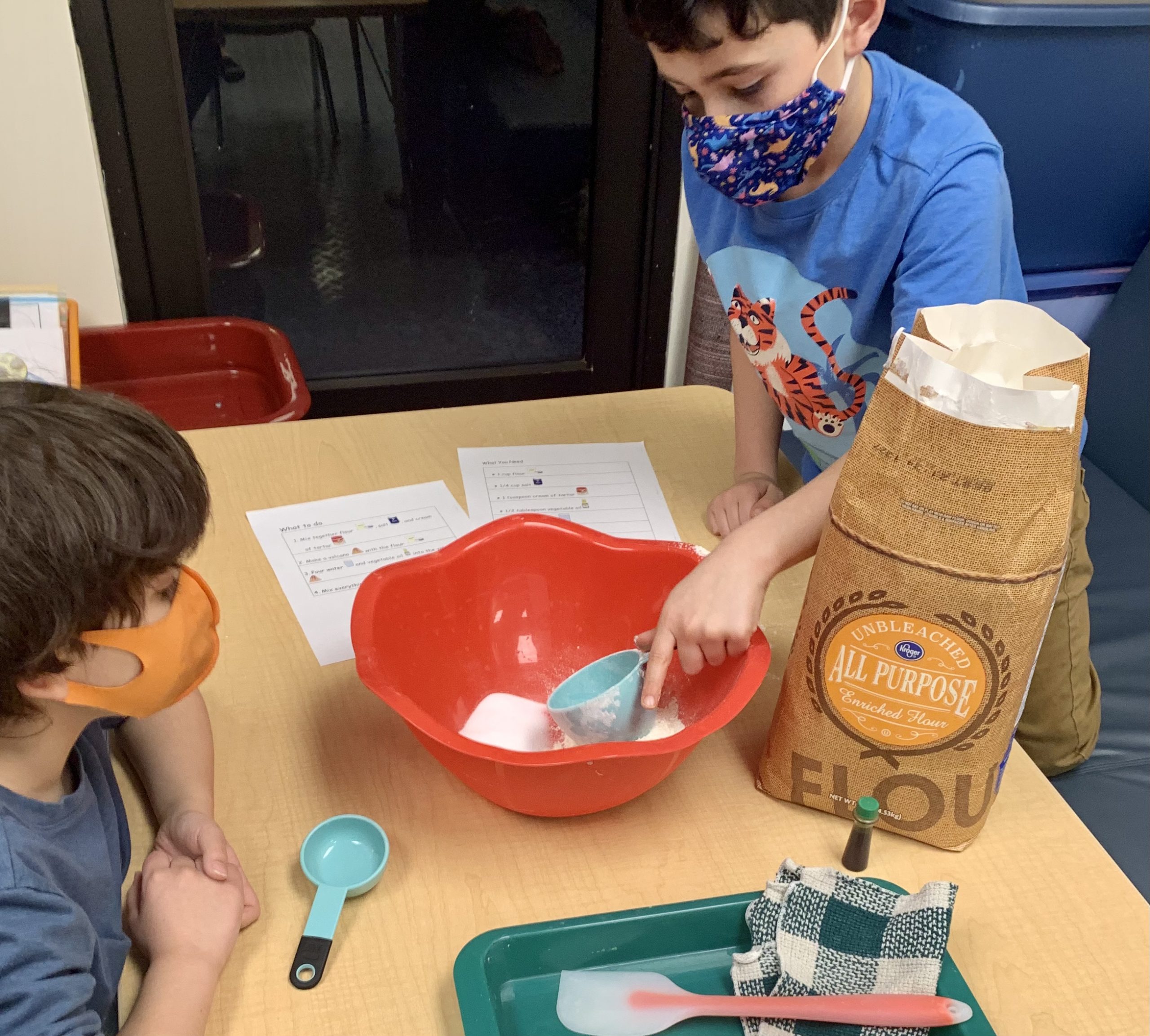 Two boys mixing up dough at The Hello Clinic.