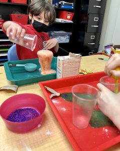 Child mixing potion ingredients in The Hello Clinic's art room.