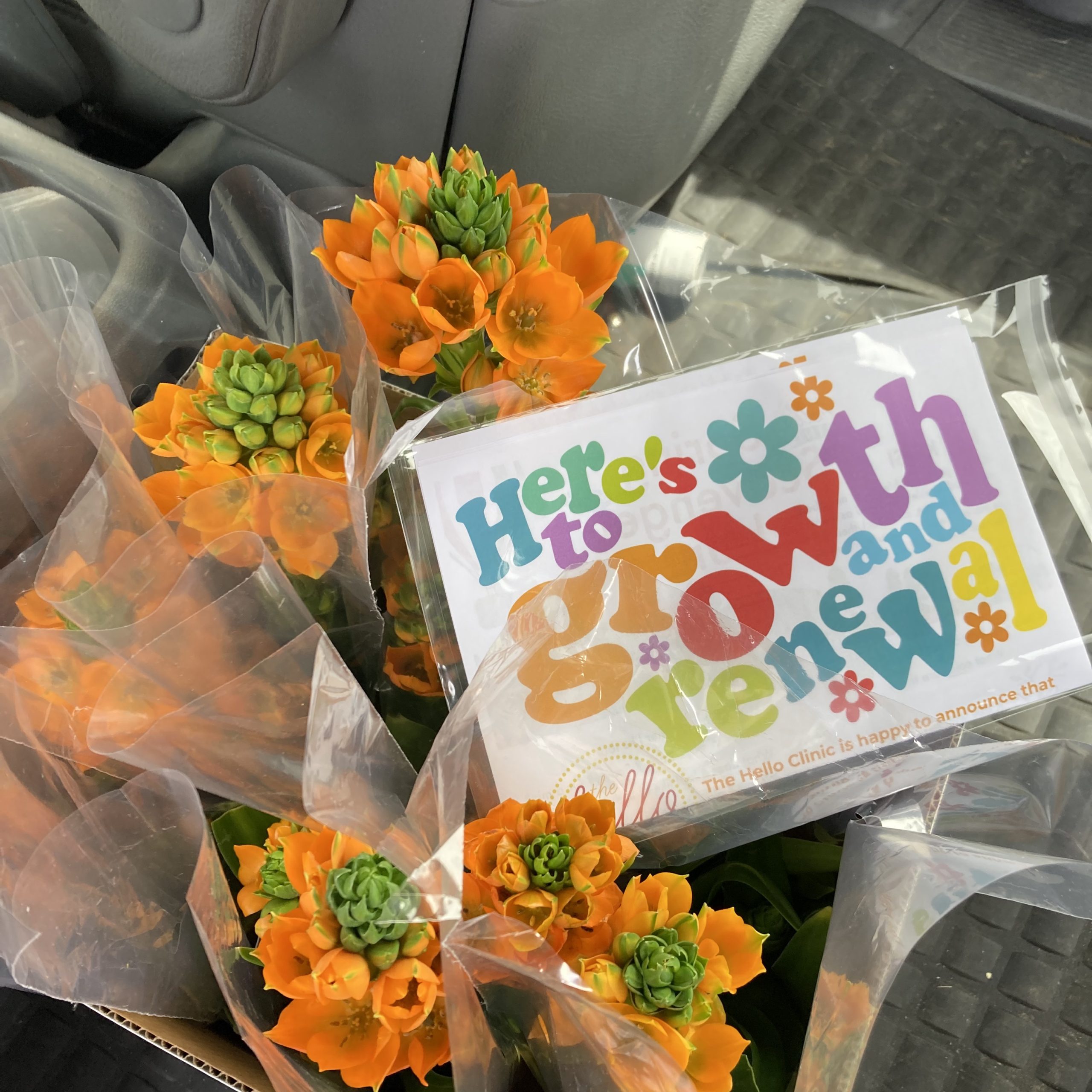 Orange flower bouquets with Growth and Renewal updates from The Hello Clinic for referring doctors' offices.